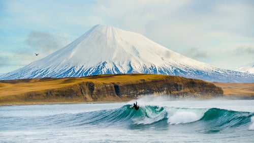 Burkard’s shot of a surfer in the Aleutian Islands graced the cover of Surfer magazine’s April 2014 issue and served as inspiration for McClellan’s seaside landscape.