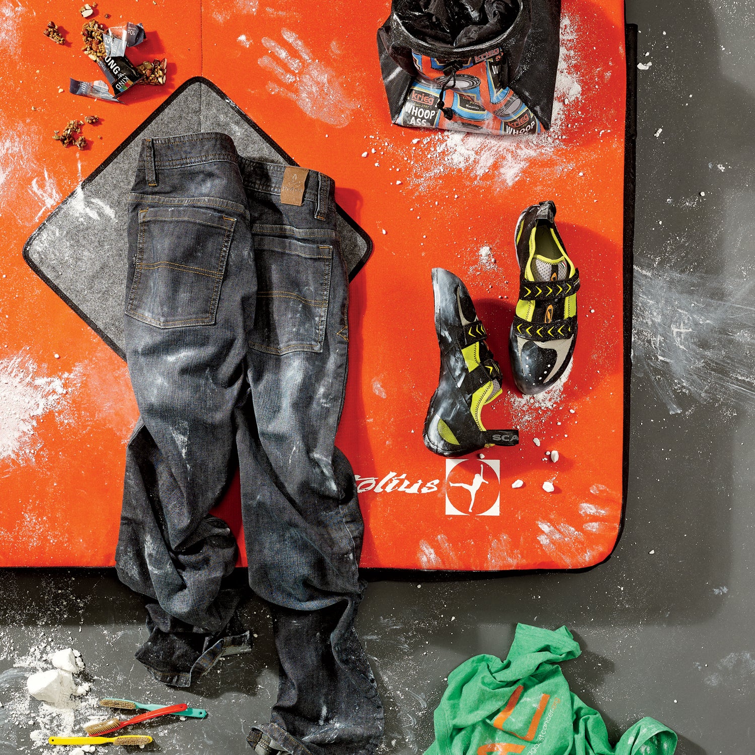 Bouldering basics. Clockwise from top left: Lapis climbing brushes, Prana Axiom jeans, Kind Strong and Kind bar, Krieg Bouldering Bucket, Scarpa Vapor V climbing shoes, Climbers Against Cancer T-shirt. Orange mat is Motolius's Session crash pad.