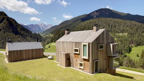 The structure features a striped wooden exterior and bumpy, limestone walls on the inside. Protruding from the building’s exterior are box windows, many of which reach to the bottom of their respective floors, allowing even small children to absorb the majestic surrounding views of the surrounding mountains.