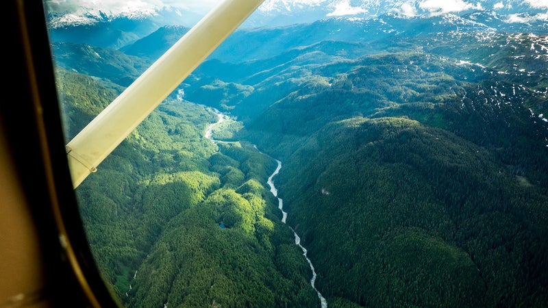 In July, 2014, conservationists and adventurers Ryan Peterson, Travis Rummel, and Gordon Klco dropped into a mountainous fortress of old growth rainforest at the source of the Unuk River in British Columbia. Ten days and 100 miles later they floated into Burroughs Bay in Misty Fjords National Monument in Alaska having completed a first source to sea descent. The expedition was undertaken as part of production for the short film, Xboundary, which discusses the region’s transboundary rivers in light of an open-pit mining boom at their British Columbia headwaters. Downstream in Alaska, these rivers are the foundation of billion-dollar salmon and tourism industries, and residents are concerned over pollution risks posed to their economy and culture. Here, Peterson walks us through a selection of the group’s images and highlights critical portions of the trip and this fragile region. Photo: Pre-trip hopes for an all-water float trip were annihilated by aerial views of impassable waterfalls and logjams—we’d have to hike. As the cessna banked hard over the upper Unuk, Rummel filled his sick sack, portending a gnarly five-day bushwhack down the (left) ridgeline—a hellish maze of colossal deadfall, granite boulders, and thorny devils club under near-dark spruce and hemlock canopy.