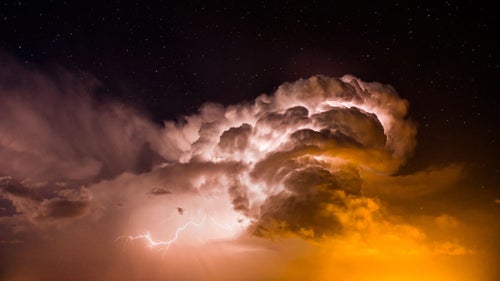 I made this image very late in the evening, as distant flashes of heat lightning illuminated the clouds. The 15 second exposure was long enough during the clear night to show the stars and the orange glow underneath the cloud was from the distant town lights.
