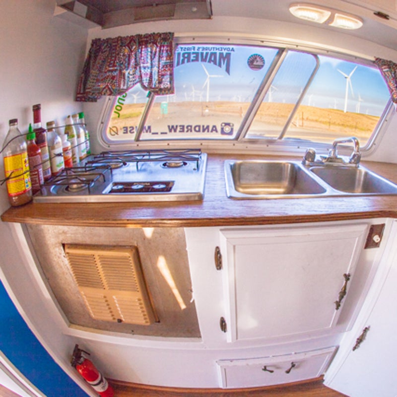 The camper came with a three-burner stove and sink, which makes life easy. The stove even doubles as a heater on extremely cold nights. I replaced the old dilapidated countertop with a piece of sanded oak that I stained. Cheap, easy, and looks great.