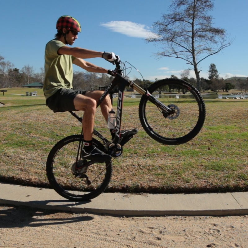 Learning to pop a wheelie makes getting over big obstacles much easier. Plus, it looks awesome. You’ll want to start with flat pedals and a gentle, grassy hill. Roll down the hill at a walking pace, keeping all your weight in the saddle. With your bike in an easy gear, put your feet in the one-and-seven-o’clock position. Next, bend your arms and shift your body weight over the handlebars, then push down on the bars to pop the wheel up while simultaneously shifting your weight back, straightening your arms and pulling back on the bars. As you do this, push your foot from the one o’clock position straight down. When your front wheel is up, your arms should be straight. Keep pedaling smoothly. Turn your bars and stick your knees out to maintain side balance. Grab your rear brake if you feel like you’re falling over backwards. To nail it, take Leech’s 30 Day Wheelie Challenge. @ryankleech