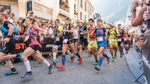Fresh off the starting line, runners—including eventual winner Nathalie Mauclair (17), Núria Picas (9, DNF) and Fernanda Maciel (41, DNF)—take off through the streets of Chamonix, France.