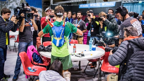 Frenchman Xavier Thévenard attracts a crowd at a nighttime aid station, prior to running a strong second 50 miles to secure his second UTMB title.