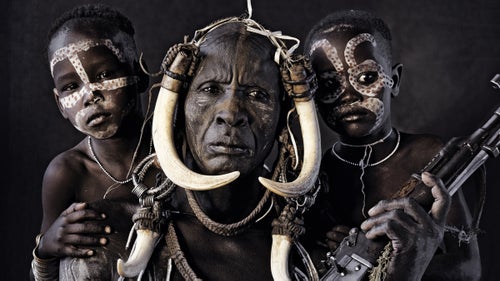 The Mursi tribe lives in Africa’s Great Rift Valley in southwest Ethiopia near the Kenyan border and number about 4,000. They are a nomadic tribe of herdsmen with their own Surmic language, Mursi, and practice many distinguishing rituals. Most famously, Mursi women are known for wearing clay plates in their lower lips. At the age of 15, girls receive lip piercings, after which their lips are stretched out to create enough space to place the lip plate. It is said that the plates were invented to make Mursi women less attractive to slave traders. In the tribe today, the bigger the lip plate, the more cattle the girl is worth by the time she is traded into marriage. In order for young tribesmen to qualify for marriage, own cattle, and have children, they must face up to a unique dare, known as the “bull-leaping” ceremony. Cows are lined up in a row. Each boy, naked, has to make four clean runs over the back of the cows without falling. Success gains him the right to marry. During this impressive display, the young man is accompanied by women of his tribe who cheer for him, dance, and sing.