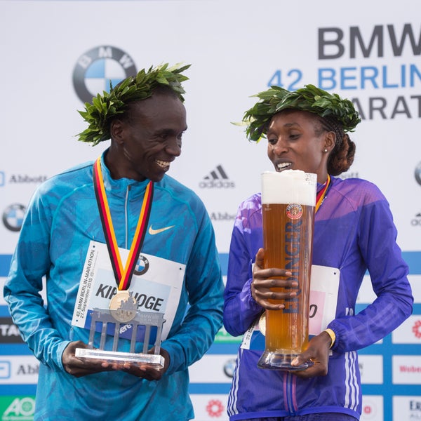 Winners Eliud Kipchoge (left) and Gladys Cherono (right) celebrate their victory on the podium during the 42nd Berlin Marathon. Kipchoge ran the eleventh fastest marathon in history.