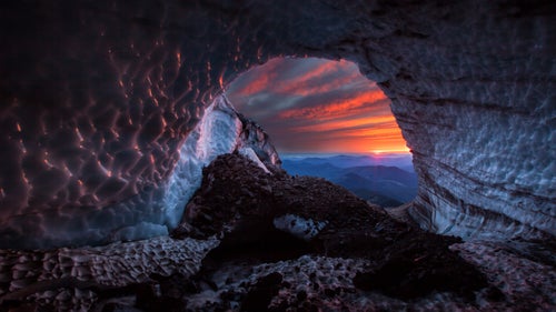 Brent McGregor first learned of the caves under Mt. Hood’s Sandy Glacier from a 2010 YouTube video that showed hikers around one of the entrances. An accomplished caver, the then 58-year-old from Sisters, Oregon, was in the midst of writing a book on the state’s caves and convinced his caving partners Eddy Cartaya and Scott Linn to help him locate an entrance.
In July 2011, the three rappelled into what is now agreed to be the largest known glacier cave system in the lower 48 states. They became the first to fully explore and map a mile-long cave and, borrowing from avalanche terminology, dubbed it Snow Dragon. Since then, they’ve located two other caves under the glacier–Pure Imagination and Frozen Minotaur–and worked with astro-biologists and geologists to analyze artifacts, like feathers and bugs, trapped in the ice and measure the caves’ rapidly changing volume.
This June, along with German climatologist Andreas Pflitsch and photographer Josh Hydeman, the team completed their third scientific expedition, hoping to figure out how these massive caves were formed and what they tell us about the glacier above.
Photo: In recent years, data collected from the cave system has unlocked an important clue in tracking glacial loss. Mass loss in glaciers has traditionally been calculated using surface measurements from aircraft and satellites, which ignore “under-ice melting” that creates cave systems. But McGregor and Cartaya have shown that in thinner glaciers like Sandy, where caves are less likely to collapse from the weight of the ice and warm air is able to circulate, mass loss from caves is significant. They hope to provide critical new information for understanding its impact on water resources and global sea level rise.