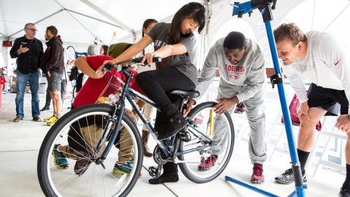 Lelani's bike gets a final inspection from two 49ers