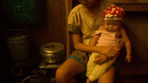 Thirteen-year-old Emma holds her seven-month-old brother, Abing, in Sei Ahass.