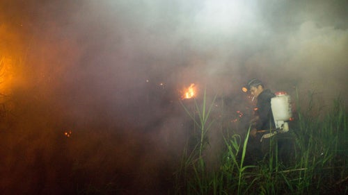 A local resident sprays down a fire near his community in Sei Ahass. “What they’re trying to do is re-moisture the peatland so it won’t burn,” Estrada says.