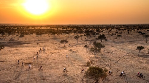 Once a year, Johannesburg-based Wilderness Safaris organizes its Tour de Tuli, a 300-kilometer (186-mile), four-day MTB ride through the Tuli Block of southern Africa, connecting Botswana, Zimbabwe, and South Africa. Unlike other multistage tours through Africa—or elsewhere around the world—this one is supported by three separate governments, with makeshift border crossings along riverbanks (you’ll need to keep your Ziploc-ed passport tucked inside your jersey, alongside your energy chews). Capped at 350 riders, plus 150 support staff, the tour fills up fast once it opens for registration each year in late November. Last August, I joined a team led by Russel Friedman, one of Wilderness Safaris’ founding partners and chairman of Children in the Wilderness, the educational program Wilderness operates in the communities outside its camps in seven southern African countries. The ride is its chief fundraiser. The course was mostly ancient elephant trails, singletracks across sprawls of loose stones, Moab-style steep cliffs and ridges; forests of swollen baobabs, fever trees, and thorny bush; plus lots of hills and sand, and hills of sand, through a pristine 3,000-square-mile tract that’s otherwise inaccessible to the public. Friedman broke his back mountain biking last year, yet at 65 he still rode me into the dust—of which there was plenty. It was the hardest multistage ride I’ve ever been on, but when you’re with some 300-plus South Africans (plus cyclists from another dozen countries), one thing’s for sure: At the end of the day, you don’t drink alone.
Photo: There are lots of ways to go on safari in Africa. By mountain bike is one of them. Fortunately, the riders, not the predators, were the only ones in “attack position.”