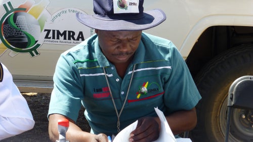 On Day 2, we crossed the Shashe River into Zimbabwe, where immigration officials sorted through our passports, dutifully writing down the serial numbers of each bill we used to pay for our entry visas. The customs officer was particularly friendly and happy to pose for photos. The logo on his shirt reads, “I am not corrupt.”