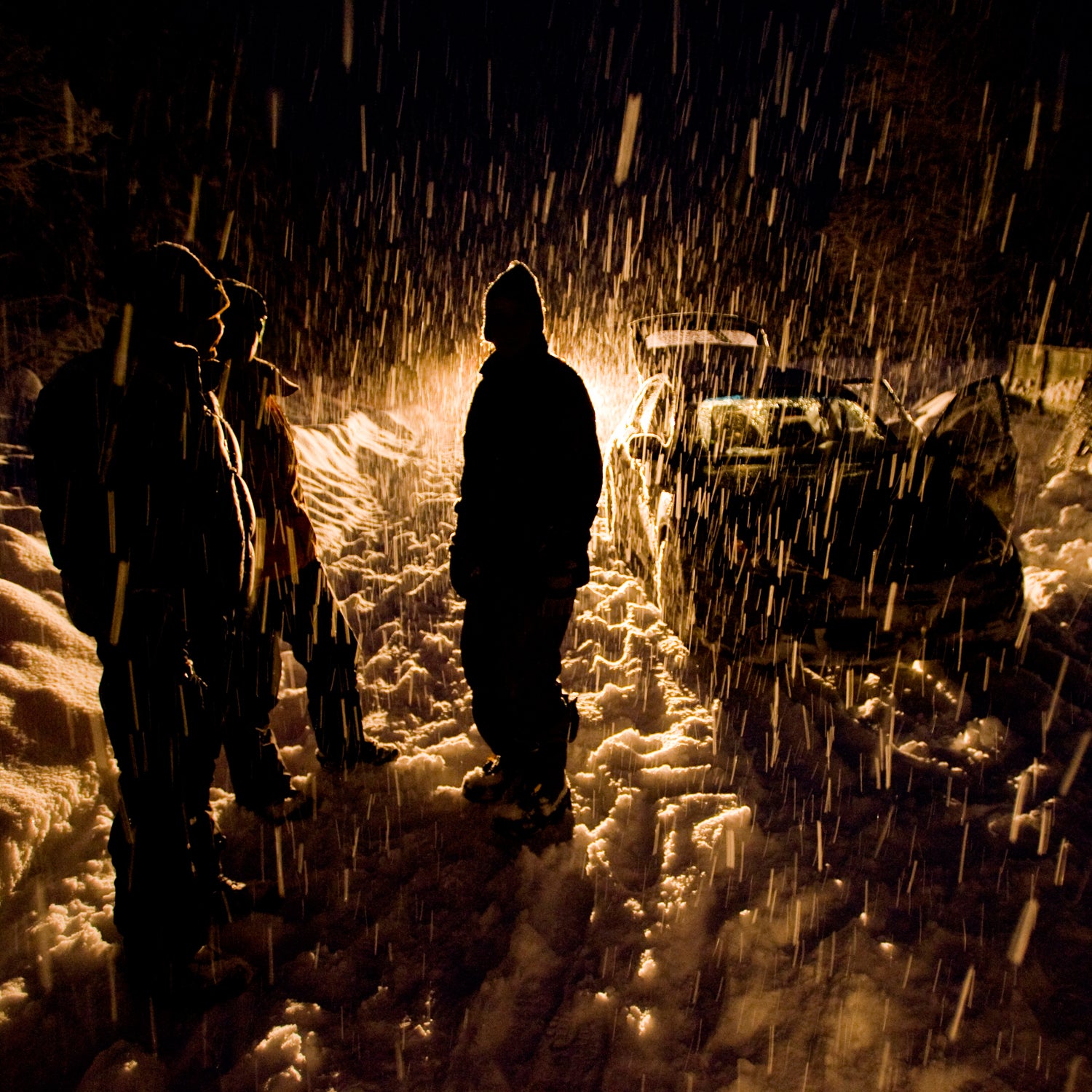 Skiers at night in a snow storm returning from a day of snowcat skiing in the Mustang Powder Cats ski mountain area, BC, Canada.