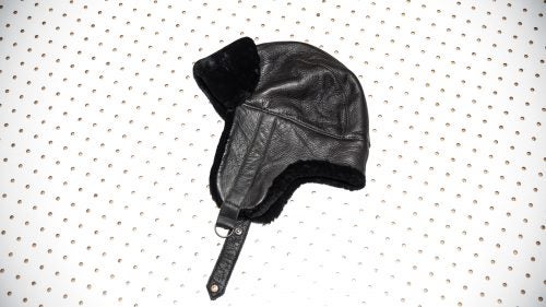 Pilots used to wear caps like the Garren to keep them warm high above the clouds. Made from leather, cotton, and shaved lamb fur, the hat features earflaps that fold up on warmer days and down when the snow starts to fly.