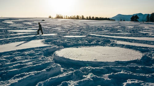Simon Beck spends a lot of his time with snowshoes strapped to his feet, clomping in circles through powder. It’s much more than a futile exercise—it’s art.
“My parents are quite proud that finally, in middle-age, I’ve accomplished something,” says the 57-year-old British artist. Beck’s achievements take the form of painstakingly detailed fractals and mandalas spanning over 300 square feet. It’s his job to travel to some of the world’s most beautiful places in search of, as he puts it, “the canvas of white and expansive.”
Beck used to make orienteering maps, so his cartography and surveying skills came in handy 10 years ago when he started mapping out the snowshoe designs, initially as a form of exercise. Now he does 30 snow murals in a season and estimates that he’s done 210 in his lifetime.
His creations are gone with the next snowfall. The longest one of his works has lasted—a mandala in the French Alps—was eight weeks. But Beck doesn’t mind as long as he can secure a photograph (ten years’ of which can be found in his 2014 book Simon Beck: Snow Art).
Outside spoke to Beck just before his second trip to Utah’s Powder Mountain (and his second time setting foot on U.S. snow), where he created the largest snow mandala made by a single person.
Photo: Although Beck requires relatively minimal equipment—snowshoes and an orienteering compass—he faces a host of potential obstacles from the elements. “Wind can destroy a drawing,” he says. “My feet get cold. Sometimes I get sunburned. The best conditions are -5 to -10 degrees, and powder snow.”