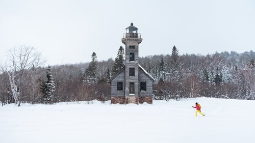 Pohl cross country skis past the East Channel Lighthouse on frozen Lake Superior en route to a shooting location.