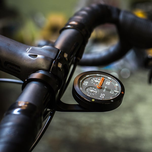 The Omata One displays speed, distance, vert, and time on a classic analog face.