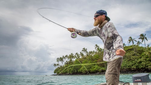 I traveled to Samoa in late March for a week of exploratory fly fishing with Australian professional angler Jonathan Jones. Both of us were hopeful about the fishery—it looked promising on maps, with wide, sweeping flats dropping off steeply past the reef edge to cuts that just look fishy. I confess to getting a little giddy on the turbulence-ridden airplane ride in from Auckland.
Halfway through the week, we were less than happy. The fishery, as it turned out, was largely fished-out. Sometimes it happens; Jonathan and I have both fished around the world enough to know this. But, damn, it’s not fun when it does.
We made the most of it, putting in long hours on the flats and in the blue water. By the end of the week, we had a few fish to hand, but, as is so often the case, the true value of the trip was meeting new people and exploring a gem of a country. Jonathan went home to the Great Barrier Reef to chase fish in waters he knows. I returned home to Montana and spent a solo day on my favorite stretch of home water, where a fat rainbow trout grabbed my fly on the third cast.
Photo: Jungle and ocean—there’s not much in between. Jonathan casts out in the channel between the two islands that comprise Samoa (Upolu and Savai’i), where little islands dot the open waters of the Pacific. After bringing up a few mahi-mahi in deeper water, we move to a reef edge in hopes of hunting up a few giant trevally. Nearby storm cells had offered a bumpy ride further out, but nestling between small islands the ride—and the casting opportunities—improve.