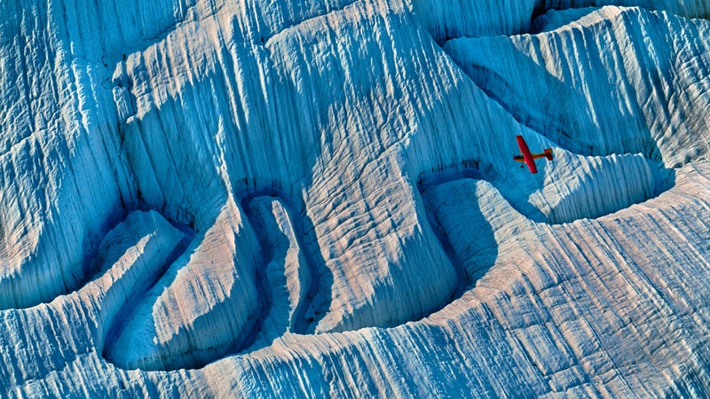 A bush plane flies over a glacier deep in Wrangell–St. Elias