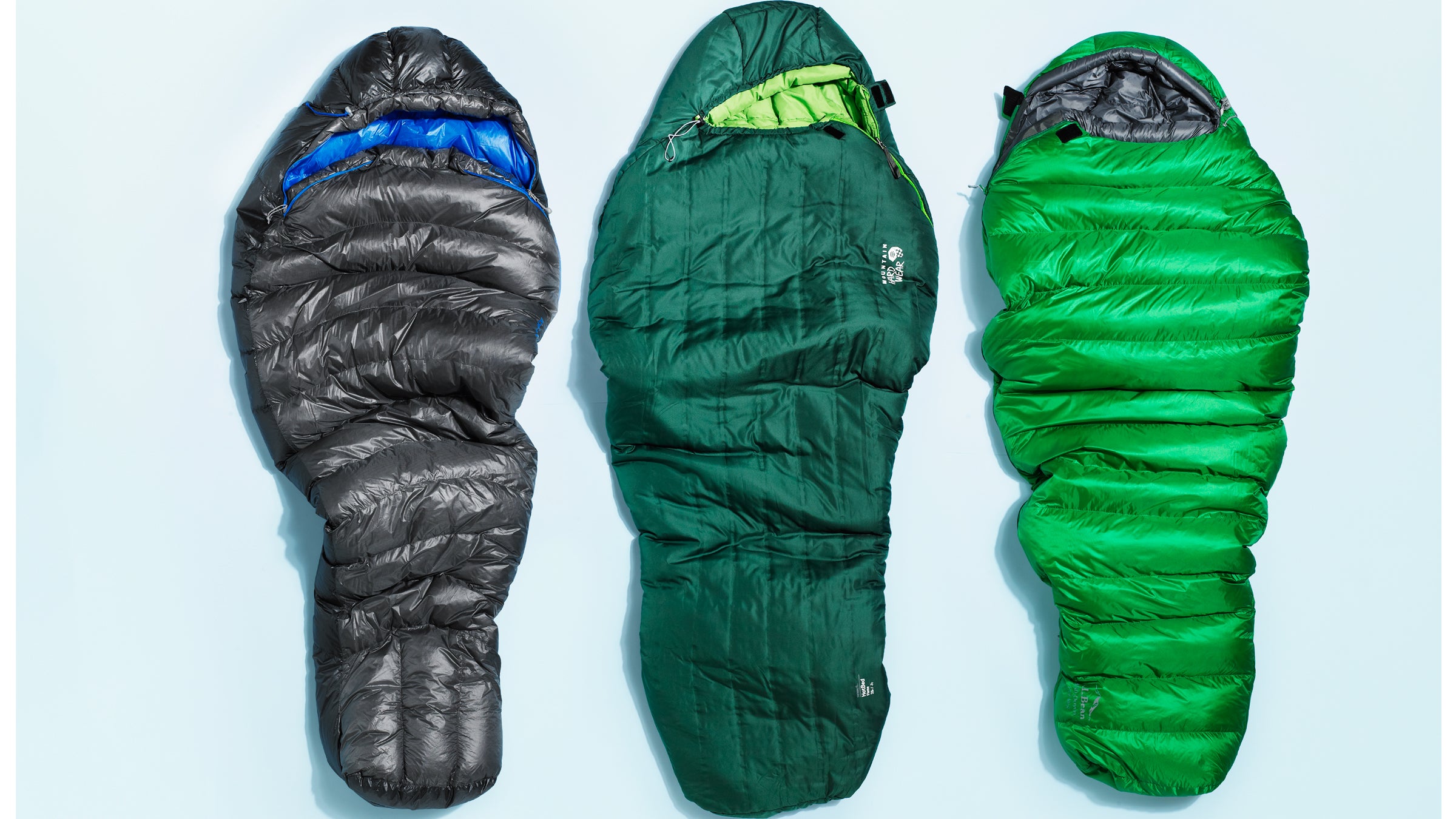 closeup of three sleeping bags on plain background