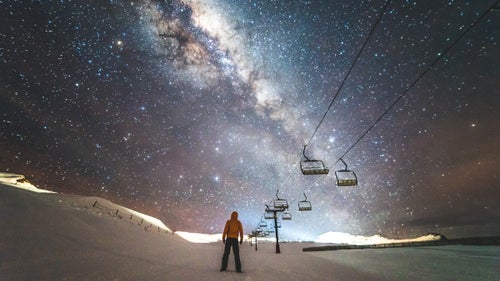 The second largest ski area in the region, Cardrona Alpine Resort, is located between Wanaka and Queenstown in the Southern Alps. It’s known for its family friendly slopes, but on a cloudless night it also offers a clear view of the stars. This was taken during what photographers refer to as the Milky Way season, which is when the Milky Way is visible—between March and October.
On one of his last nights living in Wanaka, Lolos spent the night in the chalet so that he could wake up early enough to capture the sunrise. When he saw how clear the sky was, he decided to shoot the stars as well. For this shot, he set his camera on a 30-second exposure and posed beside the chairlift. It became the photographer’s most popular shot on Instagram.