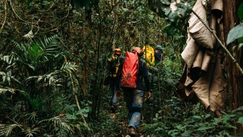 Cavers walk through a tropical forest, passing huts and farmers to access Cueva De Linda, a beautiful horizontal limestone cave in Acquismon.