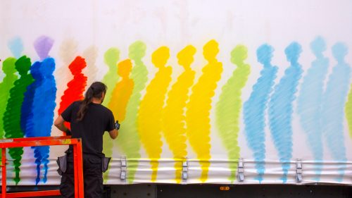 The artist known as Suso33 works on one side of his truck. Since he has experience painting larger murals and backdrops for operas, Suso33 was comfortable with the massive scale of the canvases on the truck.