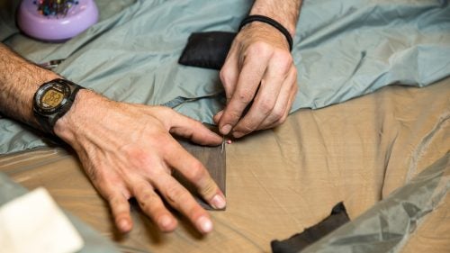 Jacobson prepares to patch a tent.