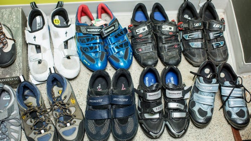 An assortment of used, repaired bike shoes on sale.