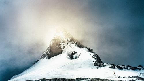One phone call with native New Zealander Graham Zimmerman led to many more, and, in March 2015, we set off for New Zealand’s South Island with two other friends, Kyle Dempster and Jewell Lund. Our objectives were simple: climb some mountains, eat some meat pies, explore. Months of planning boiled down to a few days of packing and preparation, a string of red-eye flights, and our groggy arrival in Christchurch. From there, we made fast tracks for the Southern Alps, fingers crossed for good weather that never came, with our sights set on the southwest ridge of Mount Aspiring (9,951 feet). Helicopter pilots declined to fly us to the base of our objective, so we opted for the long slog by foot, some 30 miles up the Matukituki Valley. We eventually summited via the southwest ridge. While the climb itself required some heavy trudging, what stood out in hindsight was the array of environments and ecosystems we passed through during our 72-hour descent from Mount Aspiring. We navigated across glaciers and snowfields, jungles and flooded rivers; exchanged greetings with local sheep and shepherds; and eventually arrived in the cascading heart of Fiordland, Milford Sound. Photo: We reached the summit of Mount Aspiring, at 9,951 feet, around 4:30 p.m. on March 8. Heavy gusts swept across the corniced summit. Over the next 72 hours, we traveled through myriad landscapes and microclimates as we descended Aspiring and back into the Matukituki Valley, eventually wending our way into Fiordland.