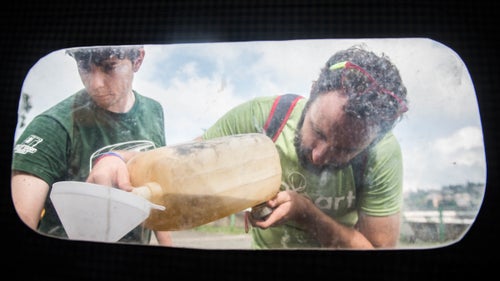 Vittorio Michelini (left) and Giovanni Testa (right), filling up one of the rickshaws’ tanks. The fuel was a mix of gasoline and oil, much like a lawn mower.