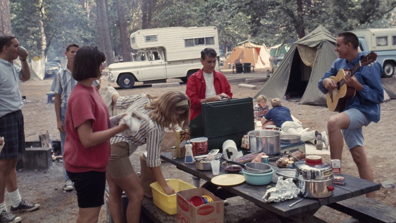 UNITED STATES - JULY 01: Man plays guitar as friends stand around pot-laden picnic table; Yosemite National Park, California (Photo by B. Anthony Stewart/National Geographic/Getty Images)