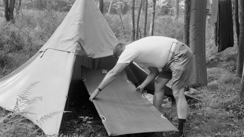 circa 1955: With his tent set up for an adventure holiday, a camper realises that his camp bed is too large for the tent. (Photo by Jacobsen /Three Lions/Getty Images)