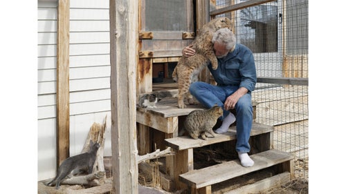 Bob and Ron; Wind River Reservation, Saint Stephens, Wyoming, 2010.
Bob is a bobcat that Ron found on the Wind River Reservation in Wyoming. Ron runs a bison ranch on the grounds of the Saint Stephens Indian Mission within the reservation, which spans 2.2 million acres and is home to Eastern Shoshone and Northern Arapaho people.
In the 1960s, the area was the center of a uranium boom. In the late ’70s, the uranium market collapsed. The Western Nuclear Corporation shut down the last mine in 1982. Many residents of nearby towns moved, often trucking their houses away with them, leaving behind rows of foundations with front steps leading nowhere. The landscape is dotted with former open-pit mines, most of them now filled with water.