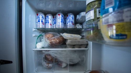 A well-stocked fridge, with eggs and beer.