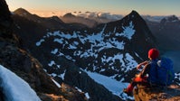 Filmmaker William Copestake watches the sunrise from the summit of Hermannsdalstinden in northern Norway.