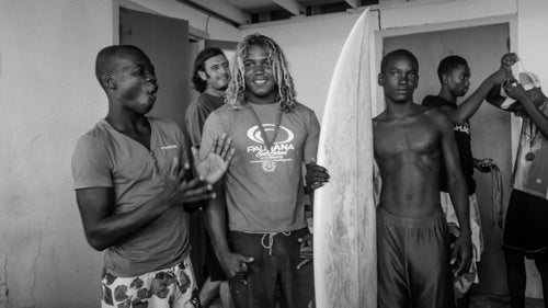 Jules reacts happily as contest winner Papito Santana donates one of his boards to another member of Surf Haiti.