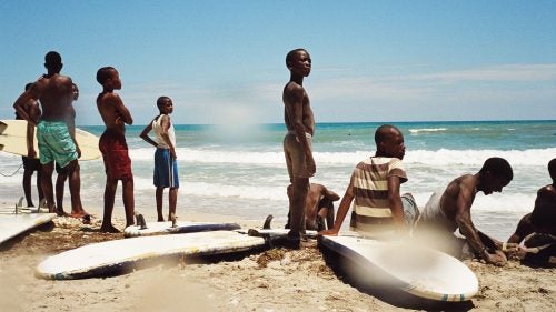 Haiti would be a rare sight on anyone's list of surfing hotspots. Despite beautiful beaches and solid breaks, the country is better known as a poster child for the failure of international aid in the wake of two devastating natural disasters—not to mention issues of violence, disease, and endemic corruption that persist today. However, since 2010 a small group of aid workers has been teaching local kids to surf the waves of Kabic Beach, roughly 45 minutes outside of Haiti's cultural capital, Jacmel. Many of these kids, despite growing up on the water, first had to learn to swim. This April, Surf Haiti hosted the country’s first surf competition matching up against a team from the bordering Dominican Republic. Photographer Mike Magers was there to capture the event, and what turned out to be a non-stop beach celebration. Photo: Contestants and spectators anxious to get back in the water while watching the heats from the beach.