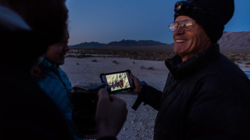 Swaney shows Navarro and Plummer the route of the first descent we’ll attempt. May 3, 2016.
The next morning, we’re up before the sun and hike in the dark for two miles while Swaney’s GPS shows zero feet of elevation gain. Our group: Jared Plummer, Stephanie Navarro, me, Aysel Gezik, and Scott Swaney. I’m the only one without multiple first descents under my belt. Around sunrise, we reach an alluvial fan dotted with fragrant creosote bushes and finally begin to gain some altitude. “What he did is a pretty cool thing,” Swaney muses about Buzz Aldrin. He says Neil Armstrong gets all the credit, but Buzz was right there with him. And yet there can only be one first.