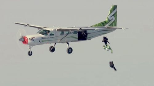 Once Aikins (in green) exited the plane, the only way he was going to survive was if he hit his target. He wore an oxygen mask for the first 10,000 feet of freefall, handing it to Farrington around 15,000 feet altitude.