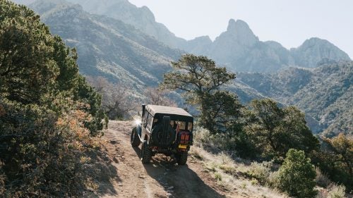 The shop removed the truck bed and replaced it with a shortened “troopy” cabin (so named because it’s made for carrying military troops). This created a truncated rear hang-over for off-roading and a spacious interior with room for a backseat. To power taller tires, they installed a 5.7-liter, 351-horsepower Chevy Ram Jet 350 engine and a reinforced five-speed transmission. They also added a twin-stick transfer case, front and rear locking differentials, and an A/C unit.