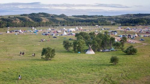 Night falls on the camp near the Dakota Access Pipeline on the edge of the reservation. Protesters first began camping here in early April, before the last winter snow had melted. By late August, thousands of people were camping in the area. Today, most of the open space in this photo is occupied.