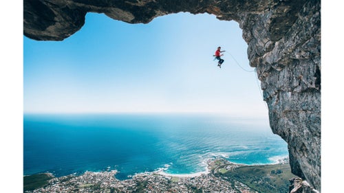 Wings category winner by Micky Wiswedel
Wiswedel and climber Jamie Smith (pictured) had been setting routes in the area. “With climbing photography it’s not often you can just walk somewhere to get a good angle—most good shots require some form of rigging,” Wiswedel says. “The angle of this image happened by chance. We were setting up for another shot but when I looked back I knew we had to change plans and grab the shot with the sea and horizon in the background, framed by this huge rock roof.”