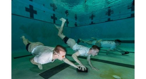 AN Fuller and AN Everette (foreground team) and AN Neaves and AN Rotz (background team) perform a water-confidence drill called
