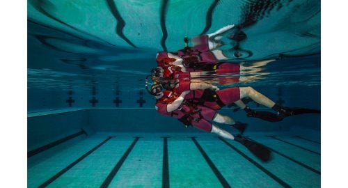 Class 119-16. AN Tyler Sojka “buddy towing” his partner, AN Anthony Troche. Sojka's hip is placed into the small of the survivor's back, and with a fast, forward kick, the survivor is raised to the water's surface.