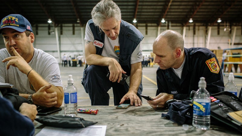Ryland Kendrick talks strategy with a fellow USAR member as Hurricane Matthew passes over Jacksonville.
