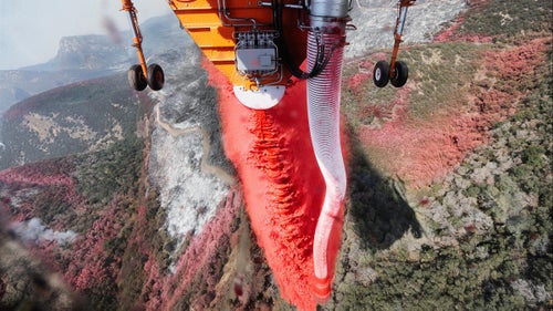 A cockpit view of a retardant drop on the Soberanes Fire in California. The long hose can draw in more than 2,000 gallons of retardant or water in approximately 30 seconds. In an area with a severe water shortage, tankers filled with water to supply the helicopters come from far away.