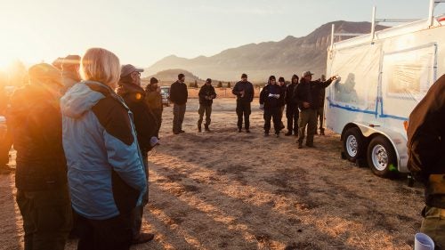 Morning briefing at the Hunter Peak Fire (2016) in Wyoming. No matter the fire’s scale, morning and evening briefings are conducted each day to give the crews and overhead staff information on what the next 24 hours will bring for each unit. Weather shifts on a fire can alter plans instantly, so communication between crews in tents and on the line is essential.