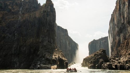 The Zambezi’s natural flow fluctuates a great deal. During the dry season (North America’s summer), Victoria Falls appears as a long escarpment of veil-like cascades, while in the rainy season, the entire canyon is a tumultuous and thundering chaos. The proposed Batoka Dam, 34 miles downstream, would create a reservoir that would lap at the bottom of Victoria Falls, possibly reducing its height. Our raft trip began just below the falls, after a 20-minute descent on foot.